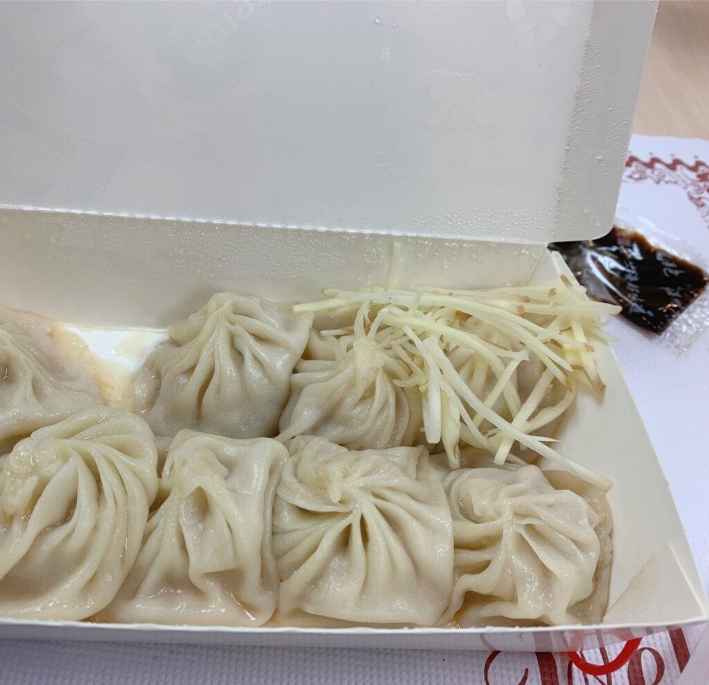 小籠包弁当の写真です。綺麗に並んだ小籠包の上に細く刻んだ生姜が載っており美味しそうな写真です。