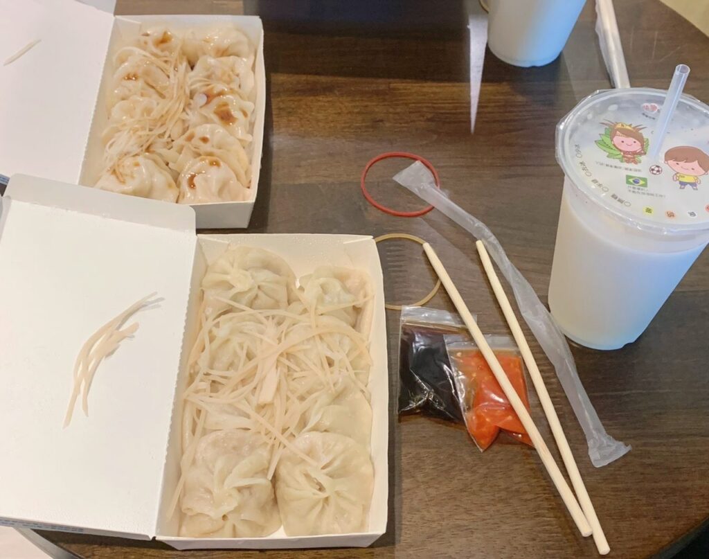 小籠包弁当と水餃子弁トプの二つが並んでいます。どちらにも刻み生姜が載っており見た目はそっくりでどっちがどっちなのか見分けがつかない二つの弁当です。